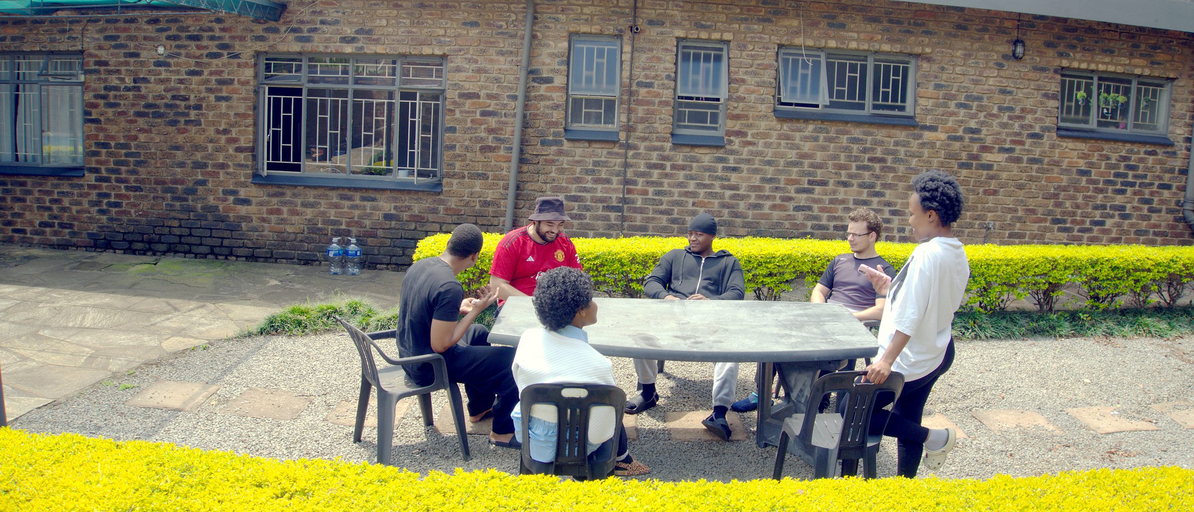 Residents sitting together at a table in the courtyard at 270 Hay Street